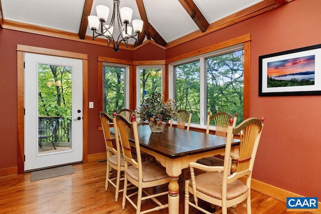 dining room with wood-type flooring, lofted ceiling with beams, and an inviting chandelier