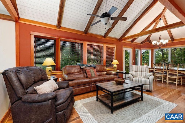 living room featuring beamed ceiling, light hardwood / wood-style flooring, and ceiling fan with notable chandelier