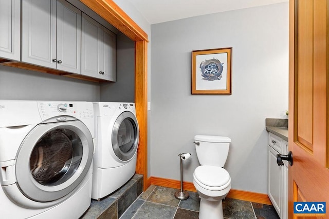 laundry room featuring dark tile flooring and washer and dryer