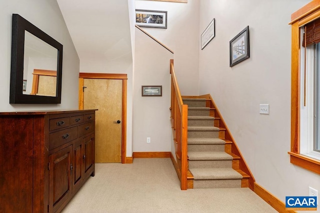 staircase featuring light carpet