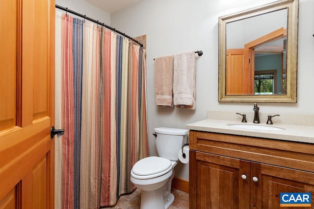 bathroom with tile floors, toilet, and vanity