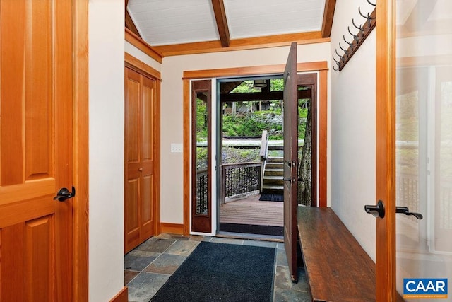 foyer featuring lofted ceiling with beams and dark tile floors