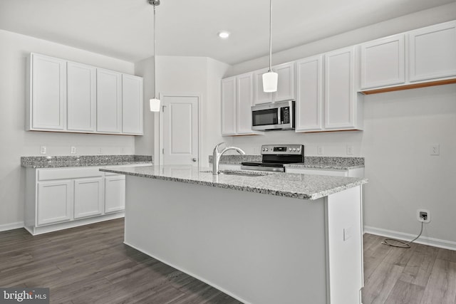 kitchen featuring hanging light fixtures, dark hardwood / wood-style floors, an island with sink, appliances with stainless steel finishes, and white cabinetry