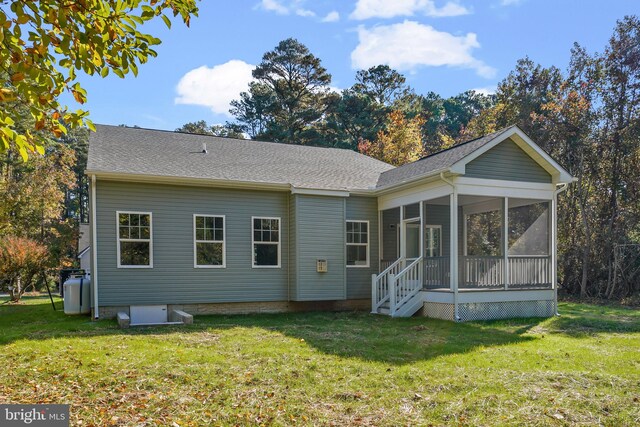 back of property featuring a sunroom and a yard