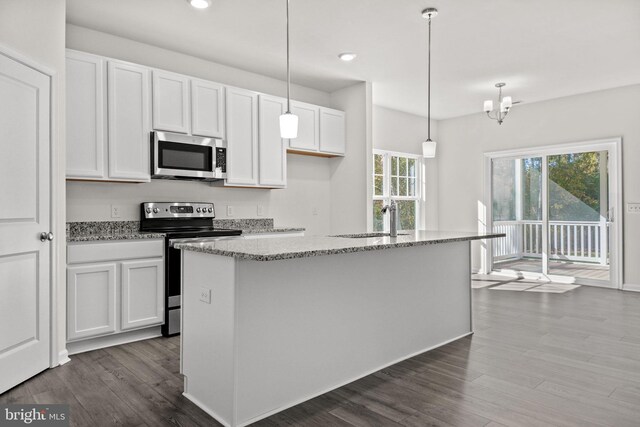 kitchen with pendant lighting, stainless steel appliances, white cabinetry, and a center island with sink