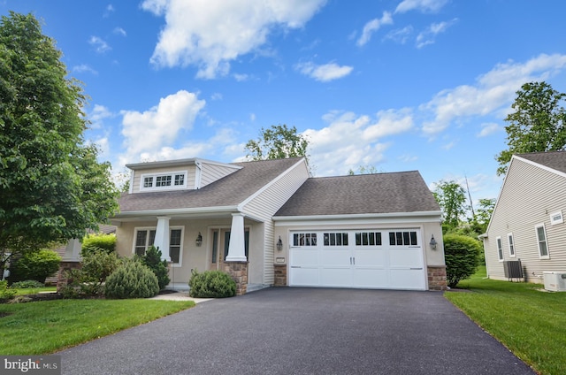 view of front of house featuring a porch, a front yard, and a garage