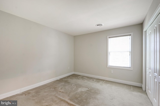 spare room featuring light colored carpet