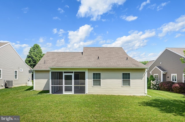 rear view of house featuring a yard, central AC, and a sunroom