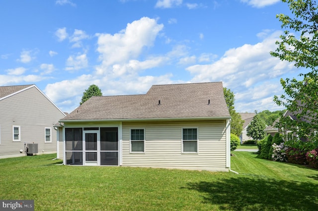 back of house with a sunroom, a lawn, and central air condition unit