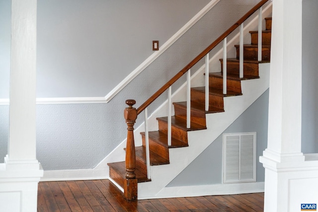 stairs featuring hardwood / wood-style flooring and ornate columns