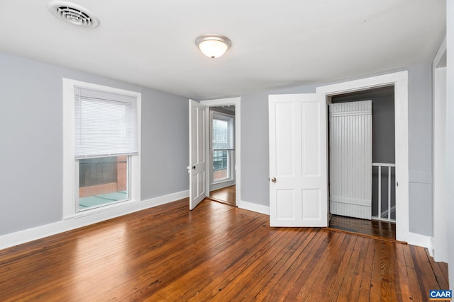 unfurnished bedroom with dark hardwood / wood-style flooring