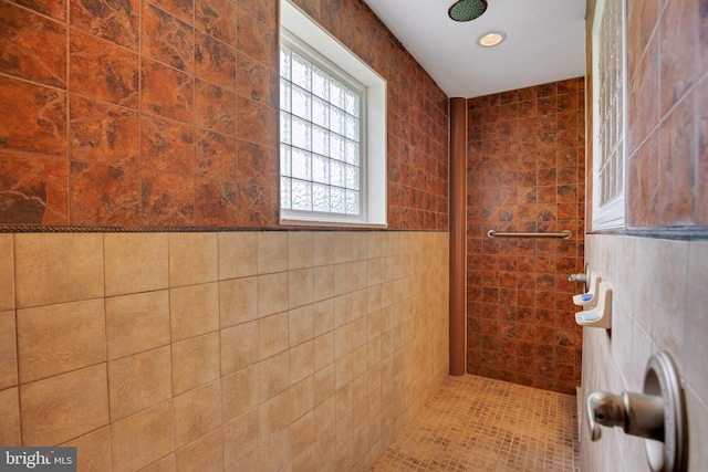 bathroom with tiled shower and tile walls