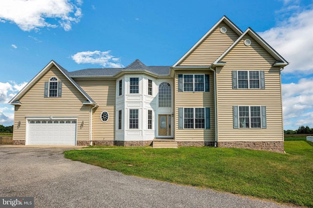 view of property with a garage and a front lawn