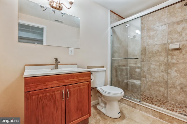 bathroom featuring tile patterned floors, vanity, toilet, and walk in shower