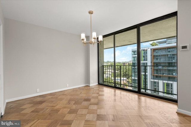 spare room with light parquet floors, floor to ceiling windows, and an inviting chandelier