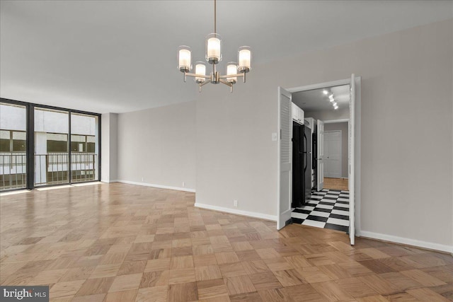 unfurnished room with a chandelier and light parquet floors