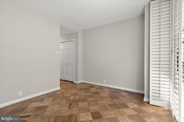 unfurnished bedroom featuring light parquet floors and a closet