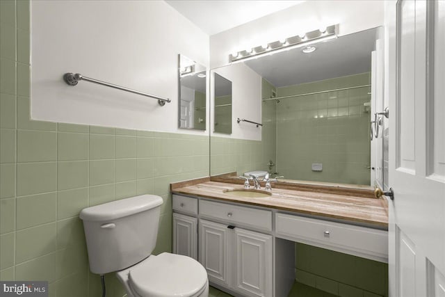 bathroom featuring vanity, tile walls, and toilet