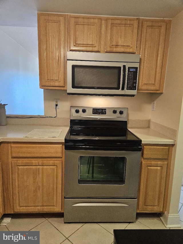 kitchen with light tile flooring and appliances with stainless steel finishes