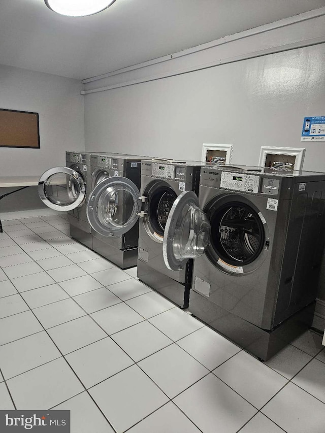 laundry room with light tile floors, washer and clothes dryer, and washer hookup