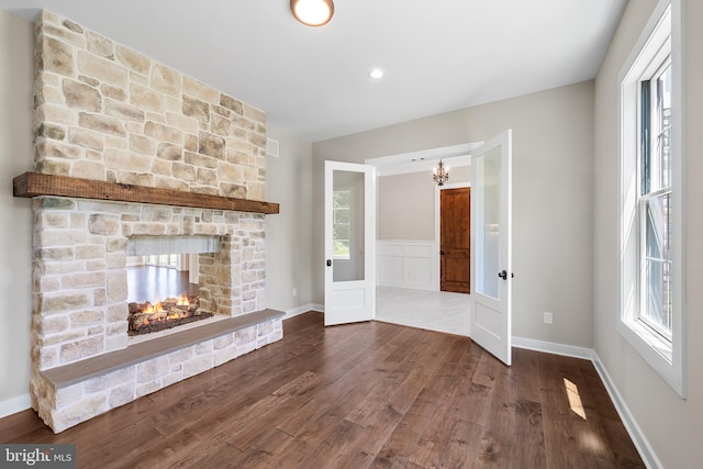 unfurnished living room with a healthy amount of sunlight, a fireplace, and hardwood / wood-style floors