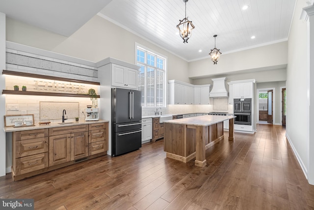 kitchen featuring dark hardwood / wood-style floors, a kitchen island, backsplash, high end refrigerator, and premium range hood