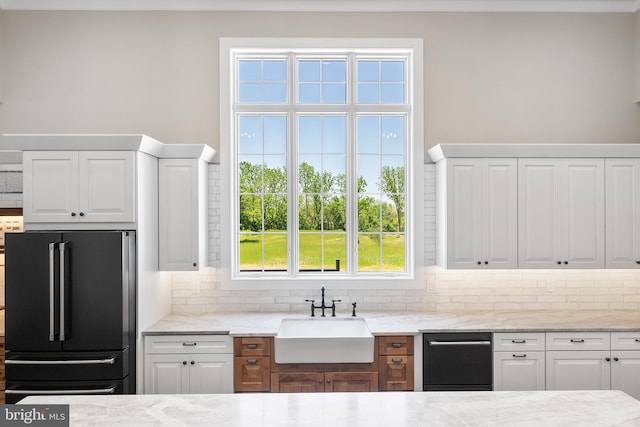 kitchen featuring white cabinets, sink, black appliances, and a wealth of natural light