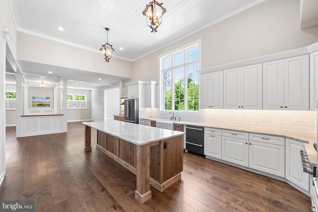 kitchen with dark hardwood / wood-style flooring, hanging light fixtures, tasteful backsplash, white cabinetry, and ornamental molding