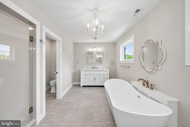 bathroom featuring tile flooring, a healthy amount of sunlight, toilet, and vanity