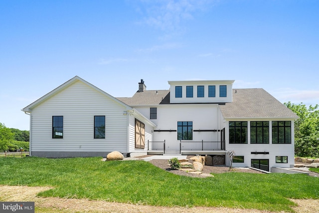 rear view of house featuring a yard