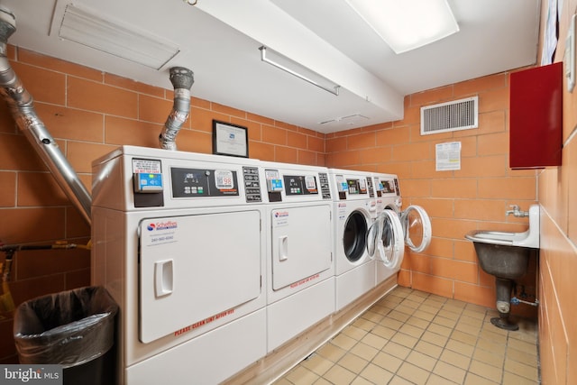 clothes washing area featuring light tile floors