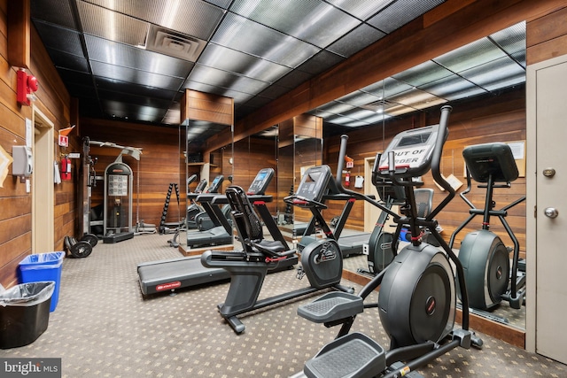 workout area with wooden walls and carpet floors