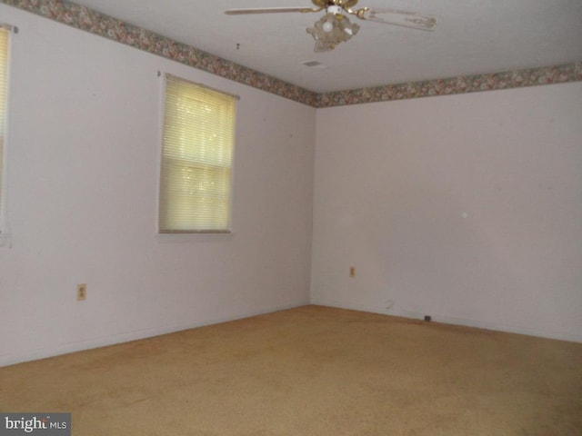 carpeted spare room featuring ceiling fan