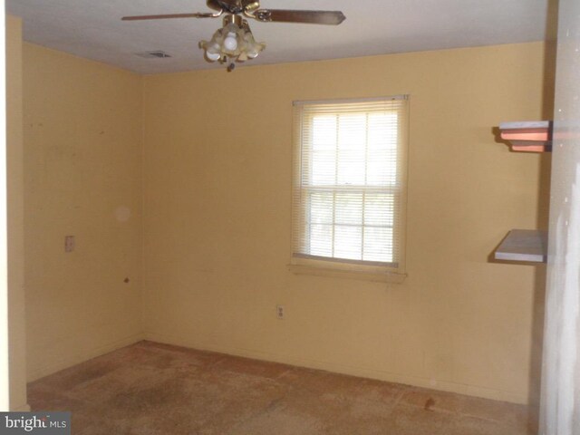 carpeted empty room featuring a wealth of natural light and ceiling fan