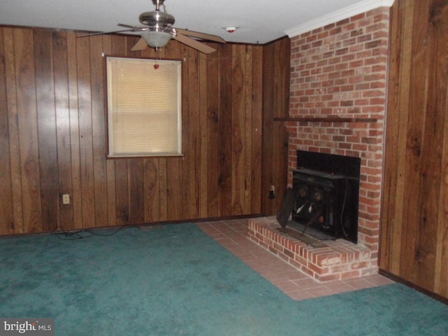 unfurnished living room featuring a brick fireplace, wooden walls, ceiling fan, and crown molding