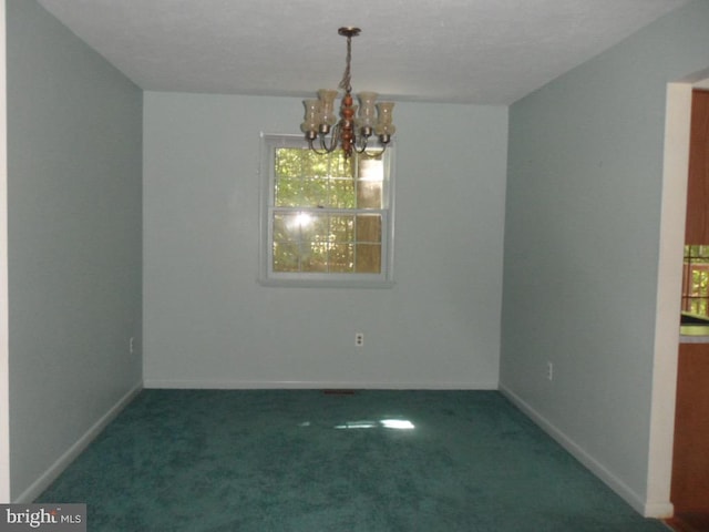 carpeted spare room with an inviting chandelier