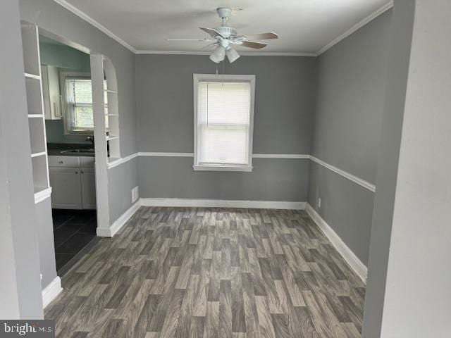 unfurnished dining area with dark hardwood / wood-style floors, ceiling fan, sink, and crown molding