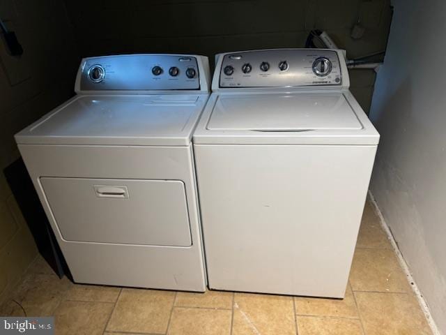 washroom featuring light tile patterned floors and washer and clothes dryer