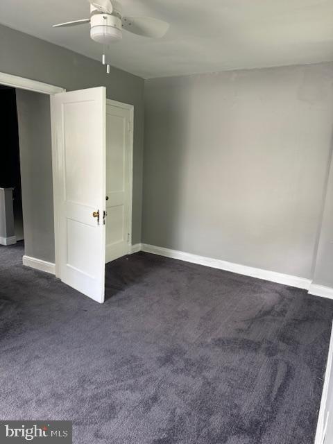 carpeted spare room with ceiling fan