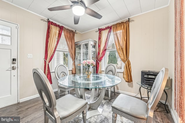 dining space with dark hardwood / wood-style flooring, a wealth of natural light, crown molding, and ceiling fan