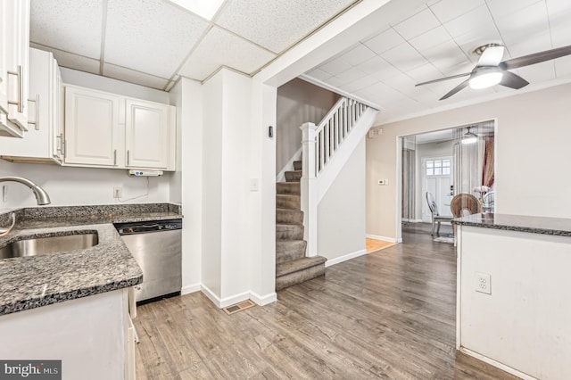 kitchen with white cabinetry, dishwasher, ceiling fan, sink, and light hardwood / wood-style floors