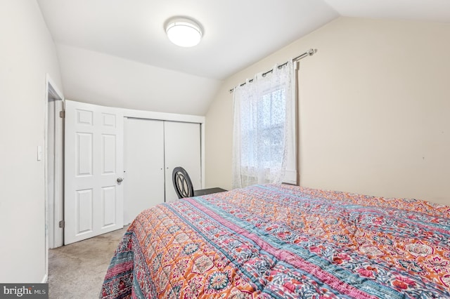 carpeted bedroom with vaulted ceiling and a closet