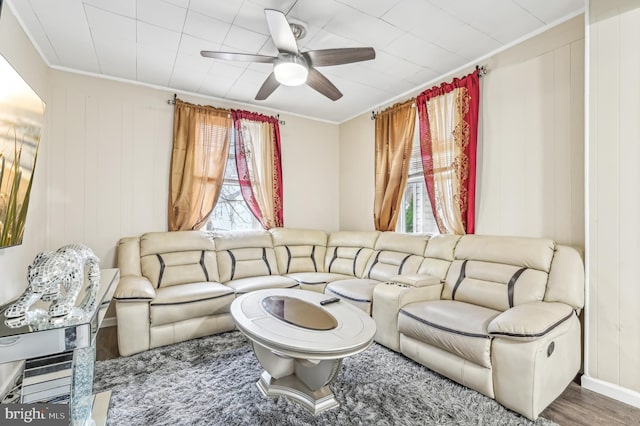 living room featuring hardwood / wood-style floors, ornamental molding, ceiling fan, and a healthy amount of sunlight