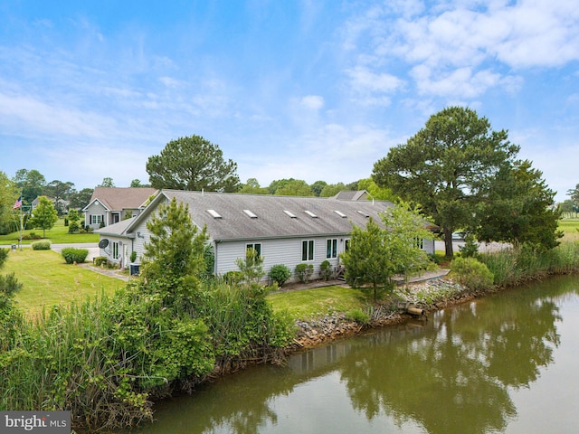 back of property featuring a water view and a yard