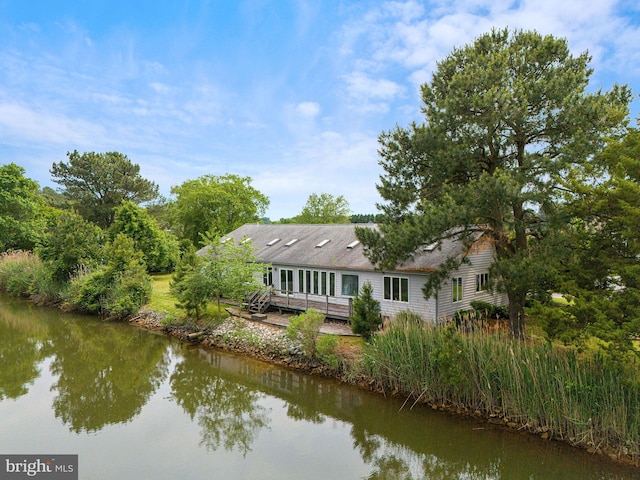 rear view of house featuring a deck with water view