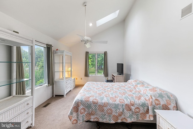 carpeted bedroom with multiple windows, high vaulted ceiling, ceiling fan, and a skylight