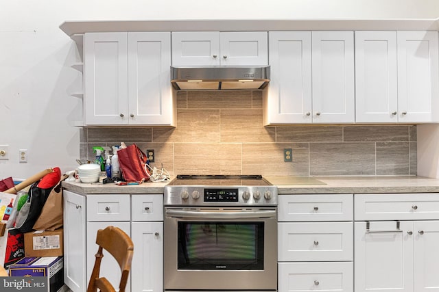 kitchen with electric stove, tasteful backsplash, and white cabinetry