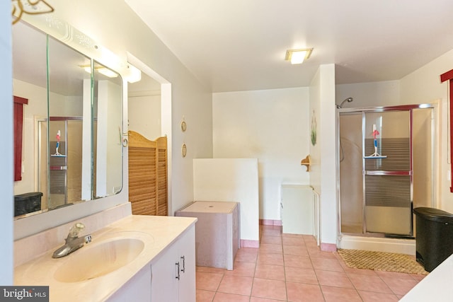 bathroom featuring a shower with shower door, tile flooring, and vanity with extensive cabinet space