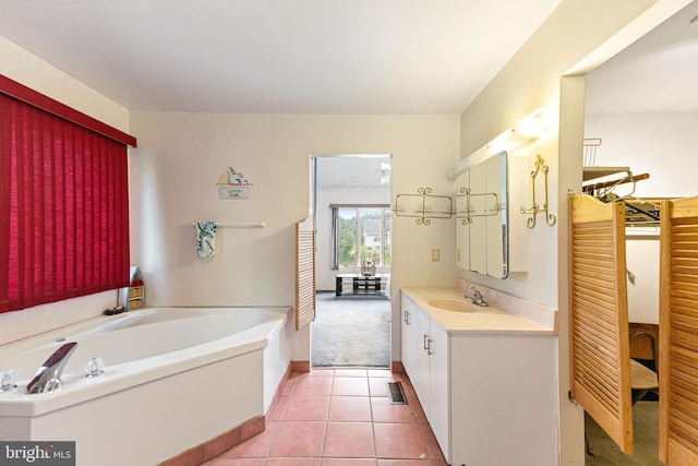 bathroom with a bath, tile flooring, and vanity with extensive cabinet space