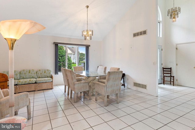 tiled dining space with a towering ceiling and a chandelier